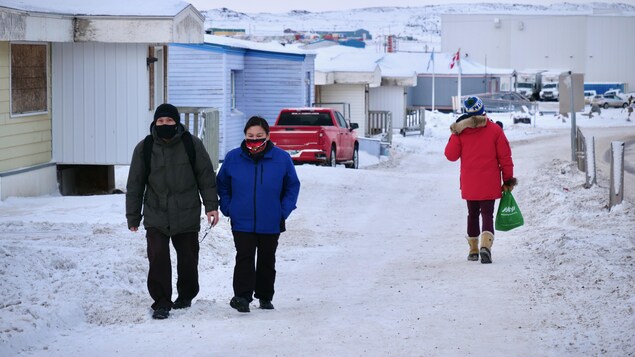 Des passants portent un masque dans une rue d'Iqaluit.