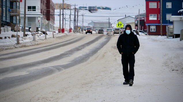 Un passant porte un masque dans une rue d'Iqaluit.