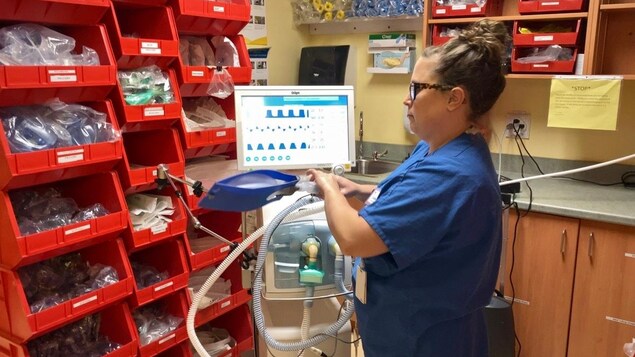 Une thérapeute respiratoire devant un respirateur.