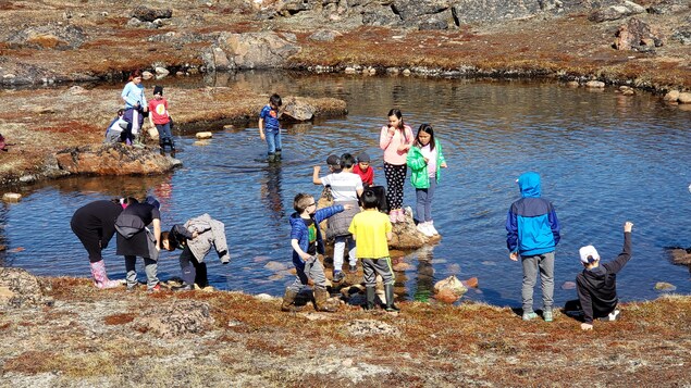 Des enfants jouent dans une rivière, près d'Iqaluit, en mai 2019.