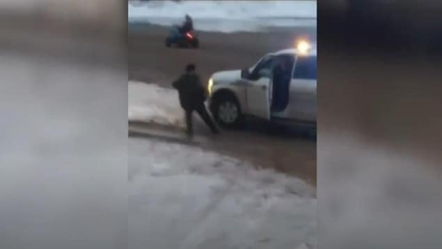 Une saisie d'écran d'une vidéo montrant l'arrestation d'un homme par un agent de la Gendarmerie royale du Canada à Kinngait, au Nunavut.