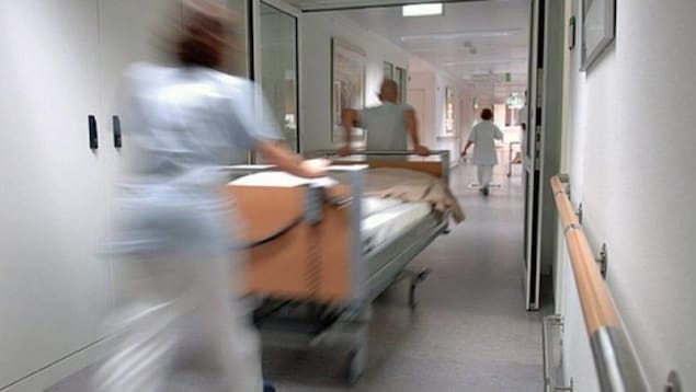 Des employés de la santé déplacent un lit