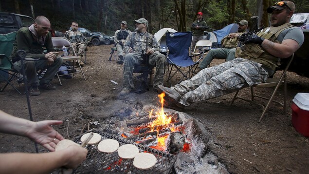 Plusieurs hommes en tenue de camouflage dans un camp. Plusieurs hommes en tenue de camouflage dans un camp.
