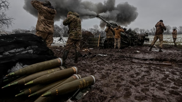 Des militaires ukrainiens tirent un obus avec un obusier M 777 sur une ligne du front.