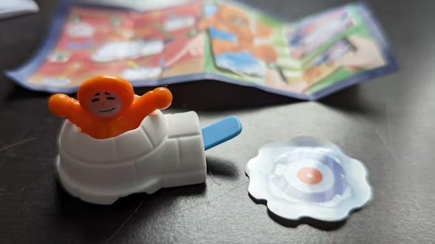 Un jouet représentant une petite figurine orange dans un igloo.