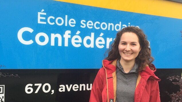 Photo d'Olivia devant le panneau de l'école Photo d'Olivia devant le panneau de l'école