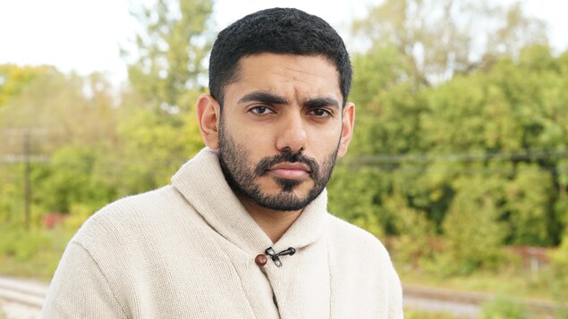 Omar Abdulaziz fixe la caméra le regard sérieux.