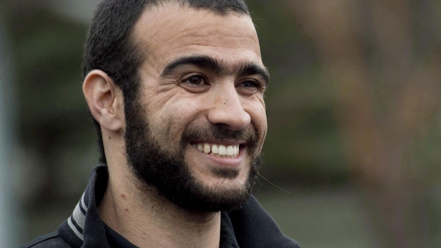 Omar Khadr, souriant, alors qu'il s'adressait aux médias à sa sortie de prison, le 7 mai 2015.