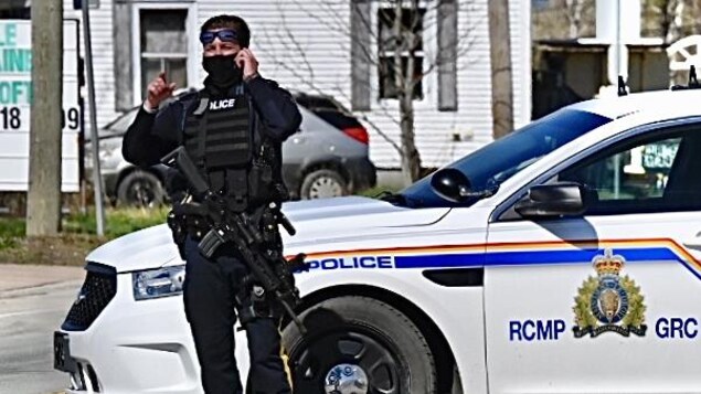 Un policier armé parle au téléphone.
