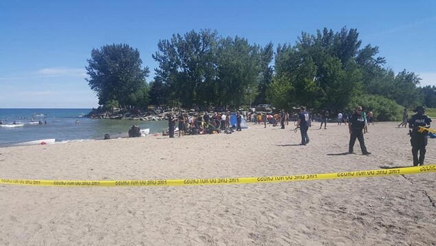 Un cordon de police et des personnes sur la plage. Un cordon de police et des personnes sur la plage.