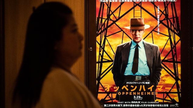 Une femme passe devant une affiche du film Oppenheimer à Tokyo.
