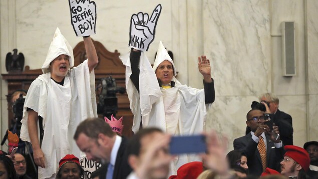 Des opposants à la nomination de Jeff Sessions se sont déguisés en membres de l'organisation raciste Klu Klux Klan pour l'audience. Ils ont expulsés. Des opposants à la nomination de Jeff Sessions se sont déguisés en membres de l'organisation raciste Klu Klux Klan pour l'audience. Ils ont expulsés.