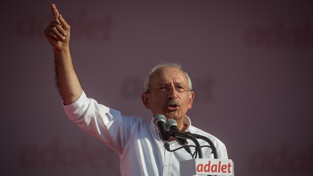 Kemal Kilicdaroglu livre un discours au micro, la main droit levée dans les airs. Kemal Kilicdaroglu livre un discours au micro, la main droit levée dans les airs.