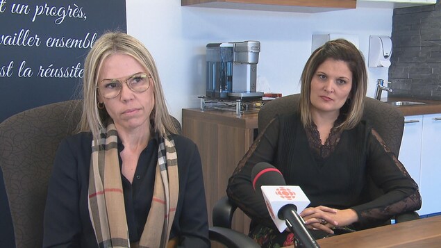 Deux femmes sont assises à une table. Devant elles, il y a un micro. Elles regardent la journaliste. Deux femmes sont assises à une table. Devant elles, il y a un micro. Elles regardent la journaliste.