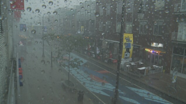 Rue de centre-ville sous une pluie forte.