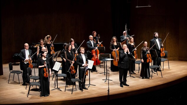 L'orchestre debout sur scène.