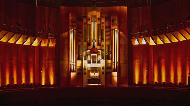 Un orgue de 11 mètres de haut et de 9 mètres de large avec un musicien qui joue.