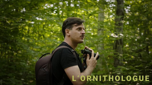 L'ornithologue Olivier Barden se promène dans la forêt, jumelles à la main.