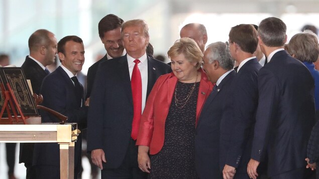 Les trois dirigeants sont entourés d'autres officiels.