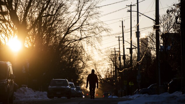 Un homme marche dans la rue à Ottawa.