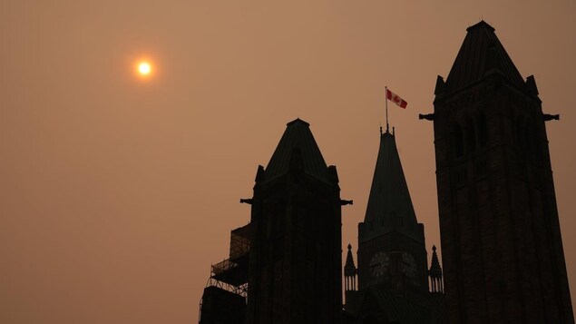 La Parlement d'Ottawa devant un ciel enfumé.  