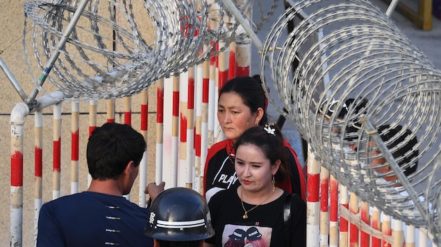 Des femmes traversant une barrière de sécurité.