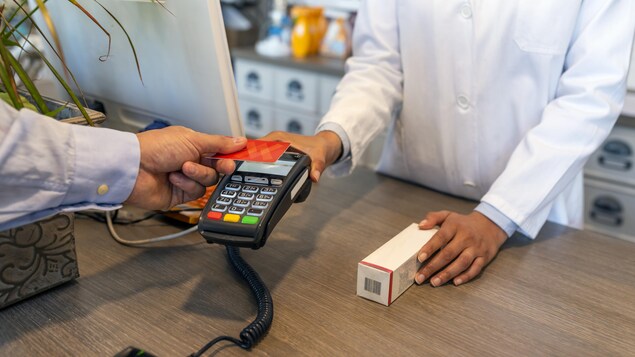 مستهلك يسدد ثمن دواء في صيدلية بواسطة بطاقة ائتمان.