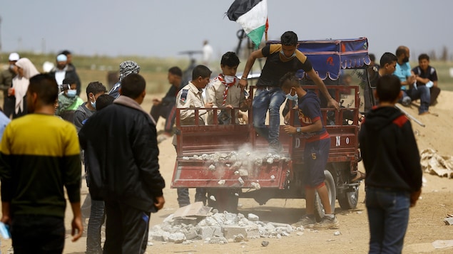 Un Palestinien vide une petite remorque remplie de débris destinés à être lancés.