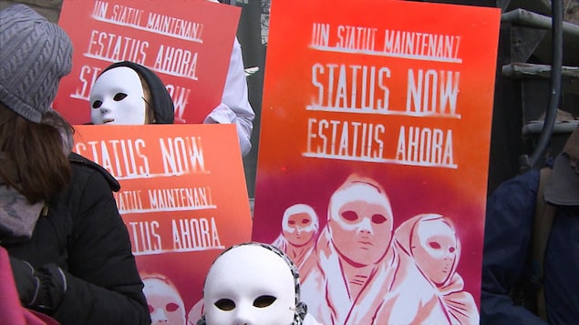 Une pancarte demandant que le statut des femmes sans-papiers soit régularisé.