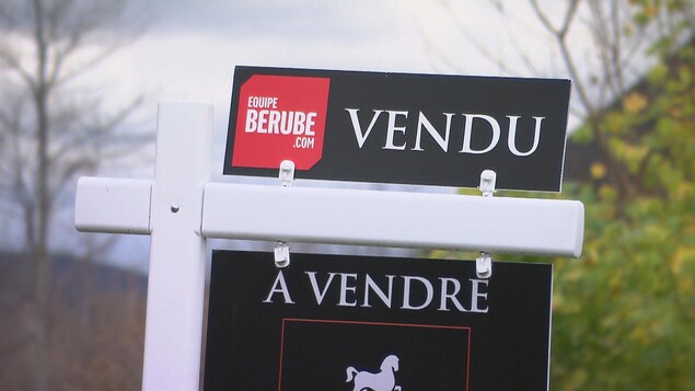 Une pancarte devant une maison vendue.