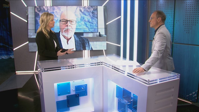 Deux personnes autour d'une table sur un plateau de télé.