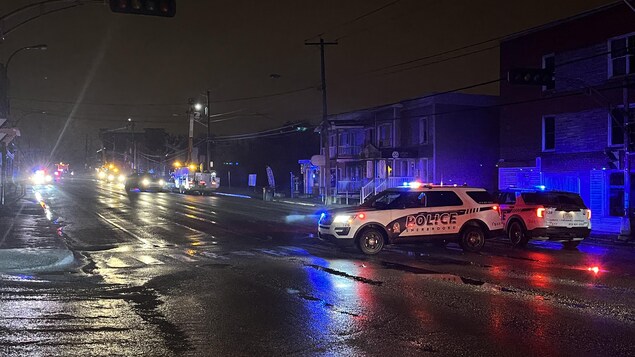 Des voitures de police sont sur le boulevard.