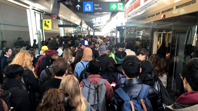 Des dizaines de personnes sont au coude à coude sur le quai.