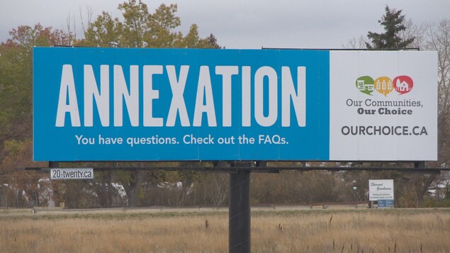 Un grand panneau publicitaire où il est écrit en anglais : « Annexion. Vous avez des questions. Consultez nos questions-réponses. Nos communautés, nos choix. Ainsi qu'un site Internet à consulter. Un grand panneau publicitaire où il est écrit en anglais : « Annexion. Vous avez des questions. Consultez nos questions-réponses. Nos communautés, nos choix. Ainsi qu'un site Internet à consulter.