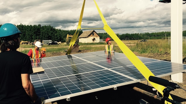 Des membres de la Première Nation Lubicon Lake, en Alberta, aident à l'installation d'un panneau solaire. Des membres de la Première Nation Lubicon Lake, en Alberta, aident à l'installation d'un panneau solaire.