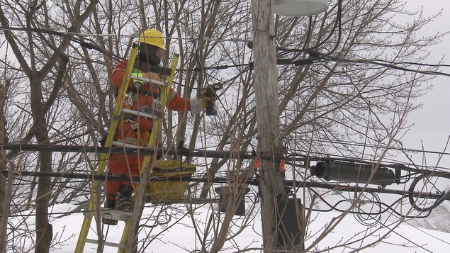 Un travailleur d’Hydro-Québec s’affaire à rétablir le courant dans un quartier résidentiel de Québec.