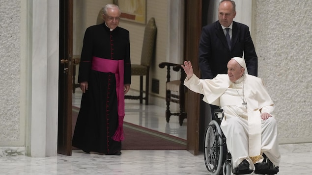 Le pape François entre en fauteuil roulant dans la salle Paul VI au Vatican. 