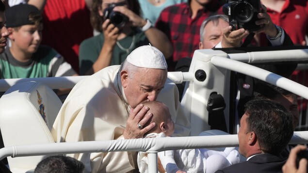 Le pape François embrasse un enfant.