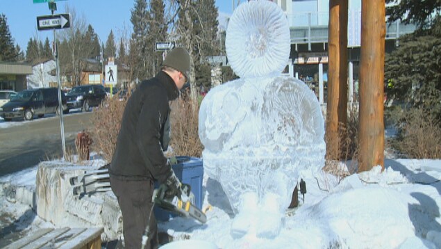 Un homme est en train de scier un bloc de glace. Un homme est en train de scier un bloc de glace.