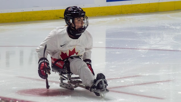 La joueuse de parahockey, Raphaëlle Tousignant, sur la luge au cercle des mises au jeu près du but.