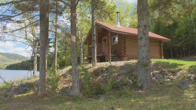 Un chalet d'allure rustique tout près d'un lac.