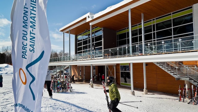 Un skieur se trouve devant le bâtiment principal du Parc du Mont-Saint-Mathieu. Un skieur se trouve devant le bâtiment principal du Parc du Mont-Saint-Mathieu.