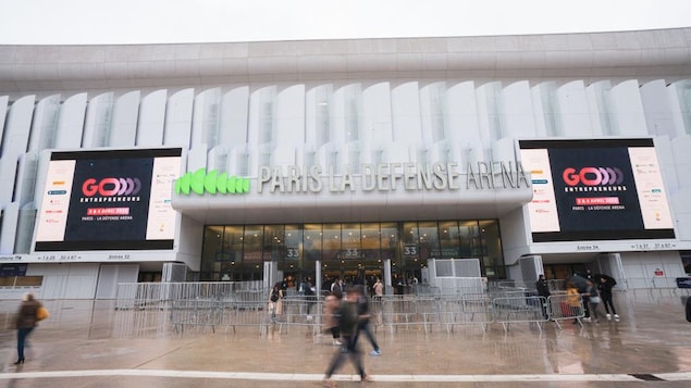 Des visiteurs passent devant l'entrée de La Défense Arena.