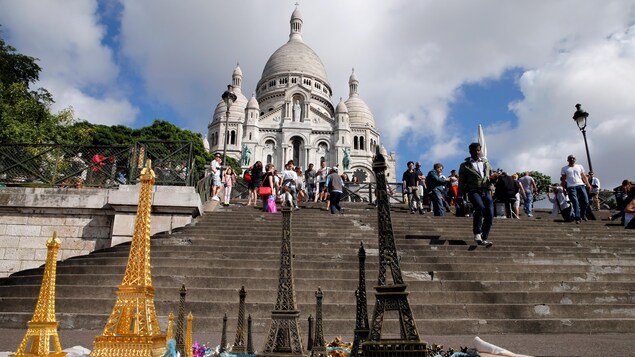 La basilique du Sacré-Coeur de Montmartre, devant laquelle des vendeurs ont étalé des modèles réduits de la tour Eiffel. La basilique du Sacré-Coeur de Montmartre, devant laquelle des vendeurs ont étalé des modèles réduits de la tour Eiffel.