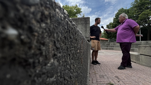 Un journaliste pose des questions à un homme.