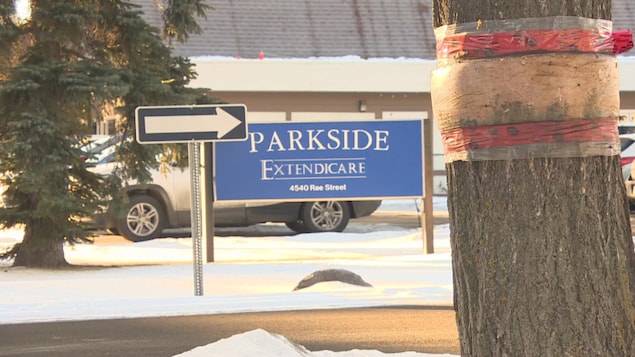 Une pancarte bleue à proximité d'un stationnement indique le centre de soins de longue durée de Regina, l'Extendicare Parkside.