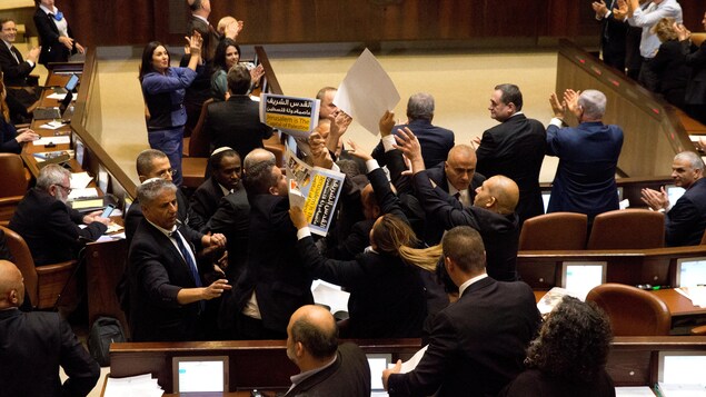 Des députés arabes israéliens brandissent des pancartes, que d'autres élus tentent d'arracher. Des députés arabes israéliens brandissent des pancartes, que d'autres élus tentent d'arracher.