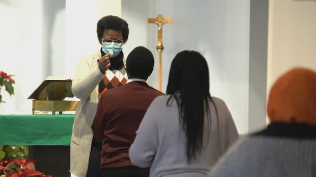 Des fidèles font la queue pendant que l'hostie est donnée à la paroisse Saint-Thomas d'Aquin à Edmonton.