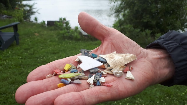 Un homme tient des morceaux de plastique dans sa main.