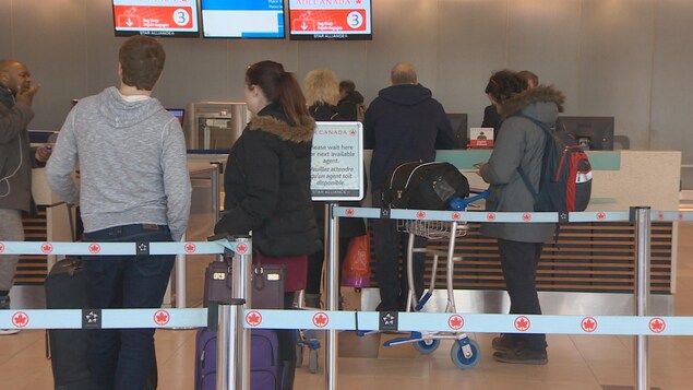 Des passagers font la file à l'aéroport d'Halifax. Des passagers font la file à l'aéroport d'Halifax.